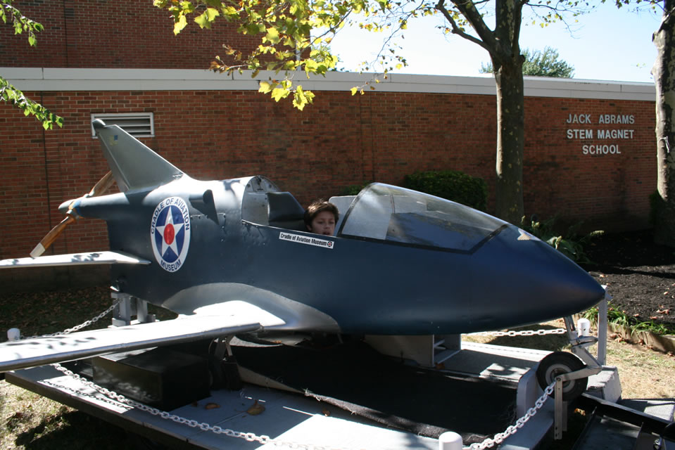 Nathaniel Coulter seated in a replica aircraft at Jack Abrams STEM Magnet School